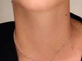 une femme portant un t-shirt noir et un collier en argent orné d'un pendentif en forme de larme