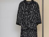 a black and white dress hanging on a rack in a room
