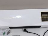 an air conditioner sitting on top of a white table next to a remote control