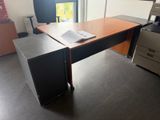 un bureau avec une imprimante posée dessus, dans une pièce