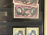 three different stamps on display in a glass case on a wall