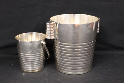silver plated pitcher and cup set on a black background
