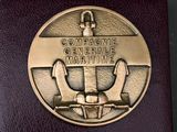 a bronze medal with the name of a marine ship on it