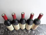 six bottles of wine are lined up in a row on a table