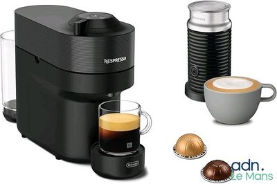 a close up of a cup of coffee next to a coffee maker