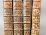 quatre vieux livres sont empilés les uns sur les autres sur une table