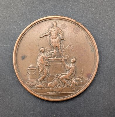 une médaille antique en bronze représentant un homme à cheval et une femme à cheval
