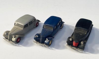 quatre petites voitures sont alignées sur une surface blanche