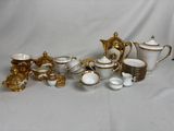 beaucoup de vaisselle en porcelaine dorée et blanche sur une table