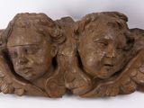 pair of carved wood heads of angels on a white background