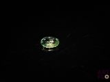 a close up of a green diamond on a black surface