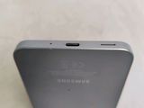 the back of a silver samsung phone sitting on top of a table