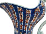 a blue and white pitcher with a red and white design on it