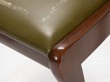 the back of a chair with a green leather seat and wooden legs