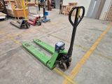 a forklift in a warehouse with pallets in the background
