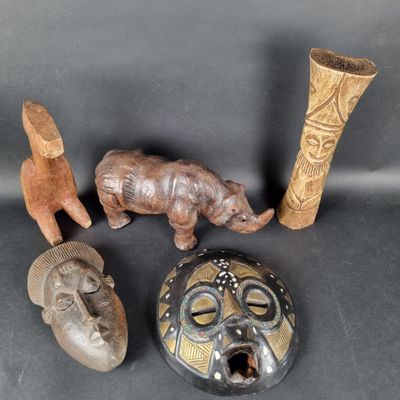 several different types of african masks and vases on a black surface