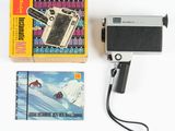 un appareil photo, un livre et une cassette posés sur une table