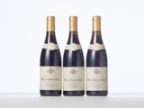 three bottles of wine are lined up on a table