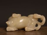 an image of a small carved animal sitting on a wooden table