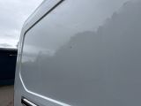a white van parked in front of a blue building