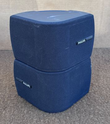 deux enceintes bleues posées l'une sur l'autre sur un tapis