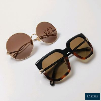 two pairs of sunglasses sitting on top of a white table
