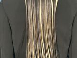 the back of a woman ' s jacket with a long fringe on it