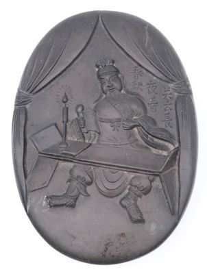 an image of a silver oval plaque with a man sitting at a desk
