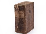 an old book sitting on top of a white surface