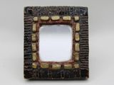 a picture of a small square mirror on a table