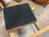 a small table with a black top sitting on a chair in a room