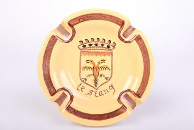 an image of a yellow ashtray with a picture of a coat of arms on it