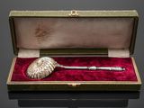 an antique silver pipe in a velvet case with a red velvet lining