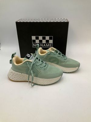 a close up of a pair of green sneakers on a white surface