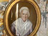 la photo d'une vieille dame dans un cadre accroché au mur