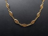 a gold plated necklace on a mannequin display