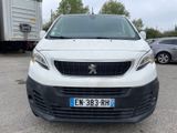 une camionnette blanche garée dans un parking avec d'autres voitures