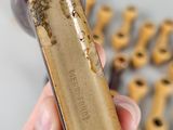 a person holding a piece of wood with a lot of wood pegs in the background