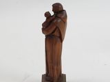 wooden statue of a man holding a child on a white background