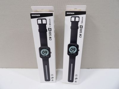 Les deux montres se trouvent dans leur emballage, posées sur la table.