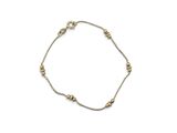 the gold beaded bracelet is shown on a white background