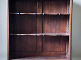 an old wooden bookcase with a shelf on top of it