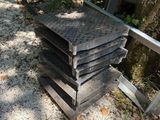 a stack of wooden pallets sitting on the ground next to a tree