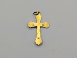 a gold cross pendant on a gray background