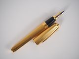 a close up of a pen and a fountain on a white surface