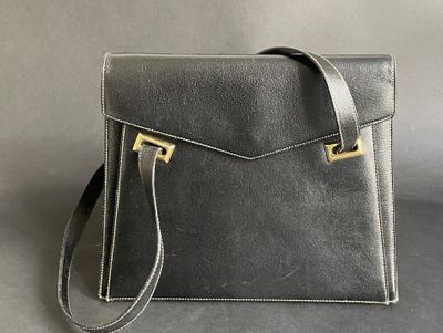 a black leather handbag with a gold clasp on the front