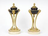 une paire de vases noirs et dorés posés sur un socle en marbre