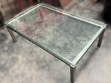 a glass table with a metal frame on top of it