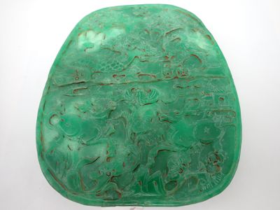 un gros plan sur un morceau de jade vert orné de sculptures