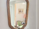 a mirror hanging on the wall next to a wall sconce